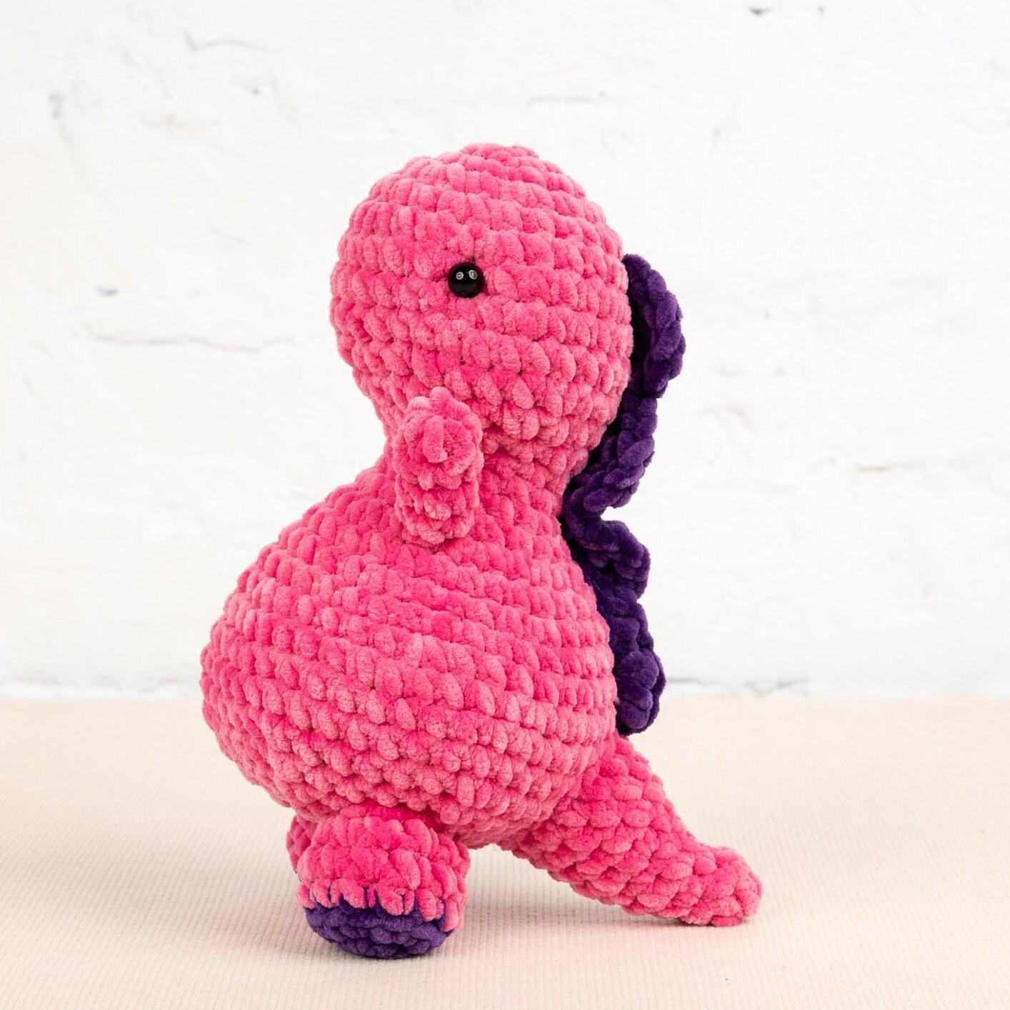 a pink and purple stuffed animal sitting on top of a table